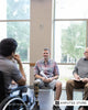 A man with lower-limb loss in a support group discussing resilience and mental health recovery.