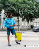 Amputee traveler with a prosthetic leg standing beside a yellow suitcase while checking their phone, representing independence and practical tips for solo travel with a prosthetic.