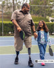 Bilateral amputee wearing an above knee prosthesis walking with his daughter.