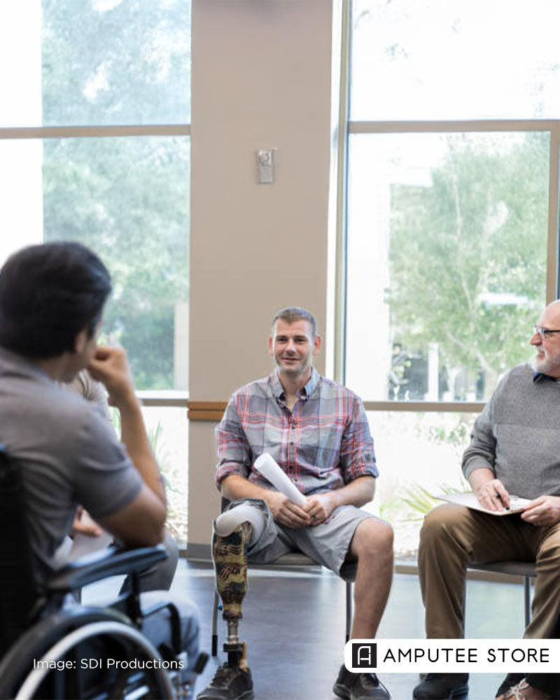 A man with lower-limb loss in a support group discussing resilience and mental health recovery.