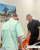 A PACE Prosthetics clinician guides a patient during rehabilitation with parallel bars, highlighting peer support and recovery after limb loss.