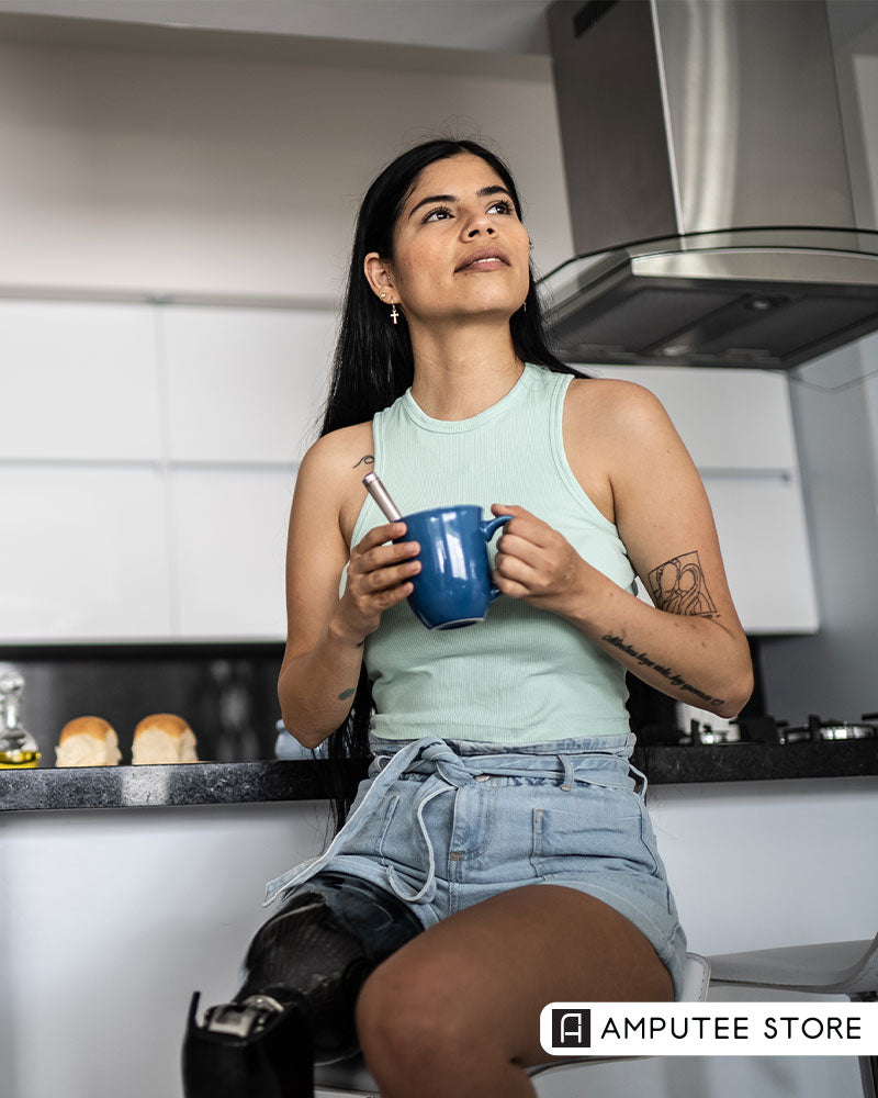 Woman with a prosthetic leg enjoying a quiet moment in her kitchen, illustrating the benefits of creating daily mental habits that support emotional well-being. 