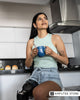 Woman with a prosthetic leg enjoying a quiet moment in her kitchen, illustrating the benefits of creating daily mental habits that support emotional well-being. 