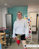 Daisy-May Demetre stands in the middle of a clinic, wearing her prosthetic legs. 