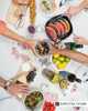 Top view of people sharing a colorful, healthy meal with fruits, vegetables, salad, and wine, representing nutrition tips for gut and heart health. 