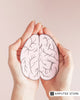 Hands holding a paper brain illustration, representing the importance of taking care of one's mental health.