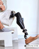 Close-up of an amputee wearing a microprocessor prosthetic leg while sitting, illustrating Medicare coverage for prosthetic limbs and amputee benefits.