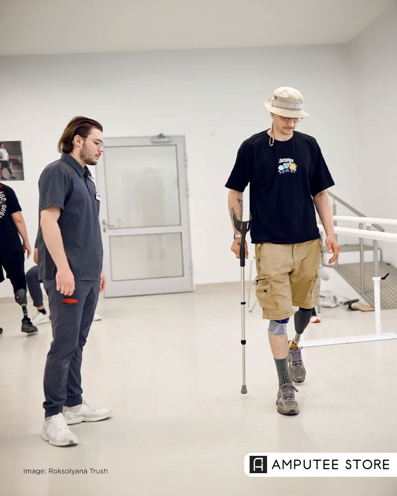 Photojournalist with a below-knee prosthetic leg practices walking with a crutch during rehabilitation after receiving mobility support funded by Kyiv Independent readers.