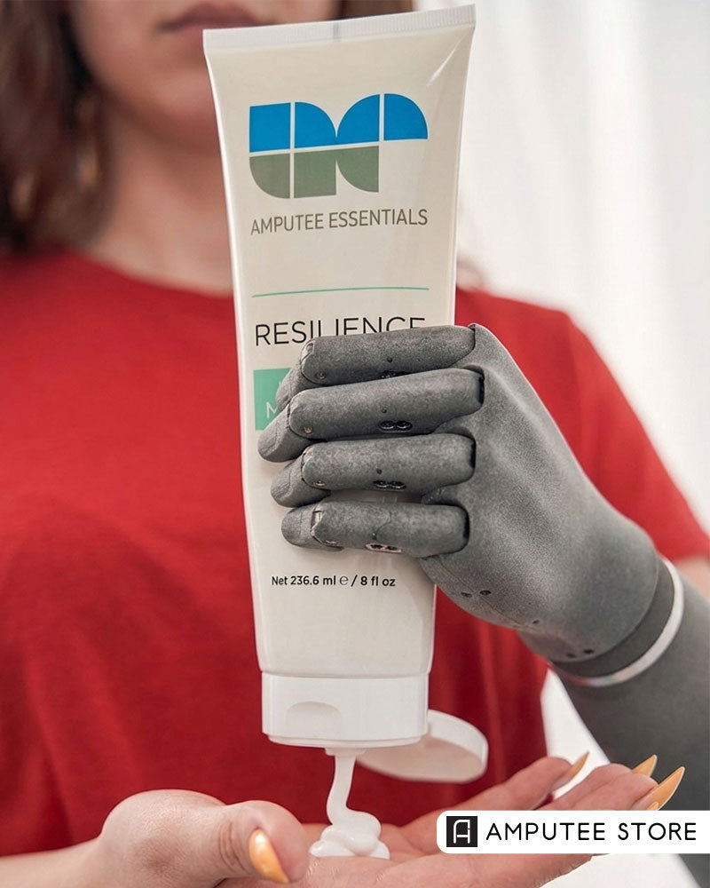 Prosthetic hand dispensing prosthetic moisturizer from an Amputee Essentials Resilience tube, illustrating skin care routines that support prosthetic comfort and residual limb health.