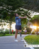 Amputee woman warming up for a morning run in the park, wearing a prosthetic leg and athletic gear, symbolizing motivation and progress toward goals.