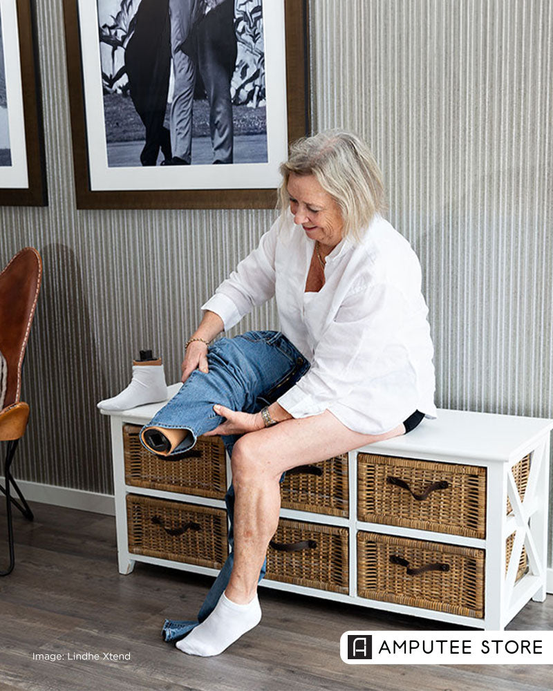 Woman with lower-limb loss preparing to attach a prosthetic foot using a quick-change prosthetic adapter that allows foot swapping in seconds.