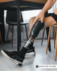 Person adjusting below-knee prosthetic leg indoors, illustrating compounding issues caused by a poorly fitting prosthesis.